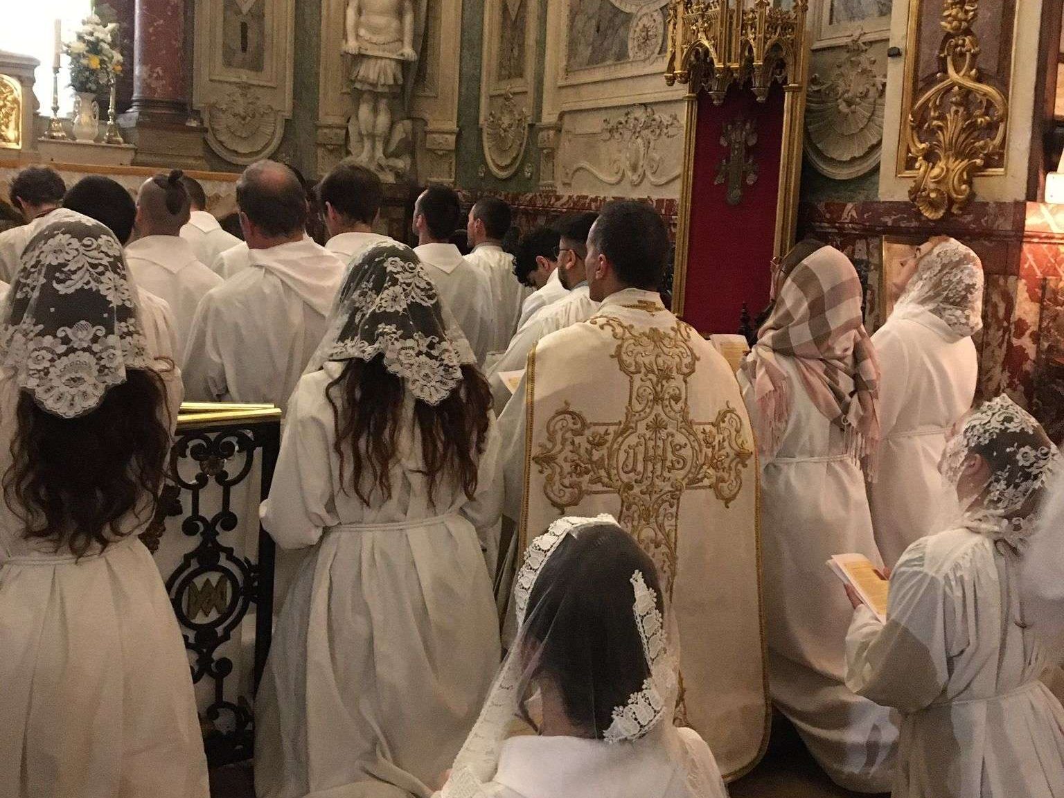 catholiques en train de prier avec le prêtre