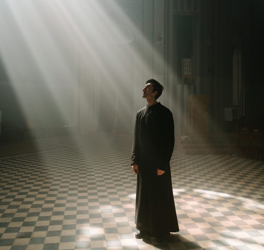 prêtre éclairé par une lumière dans une église