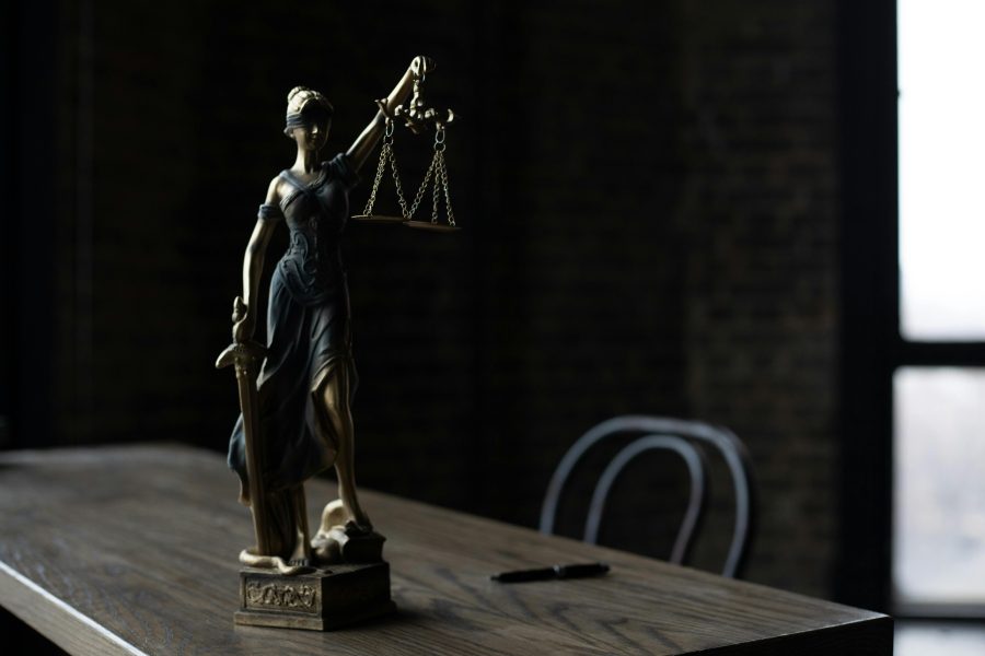 une statue avec une balance et une épée posé sur une table représentant le moindre mal