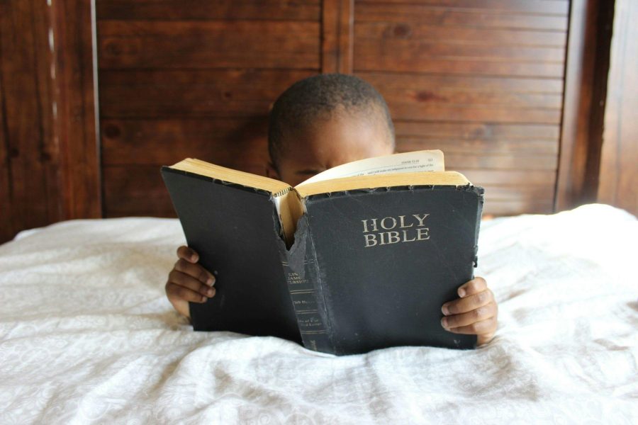 image d'un enfant lisant la Bible ce qui lui apporte des indulgences