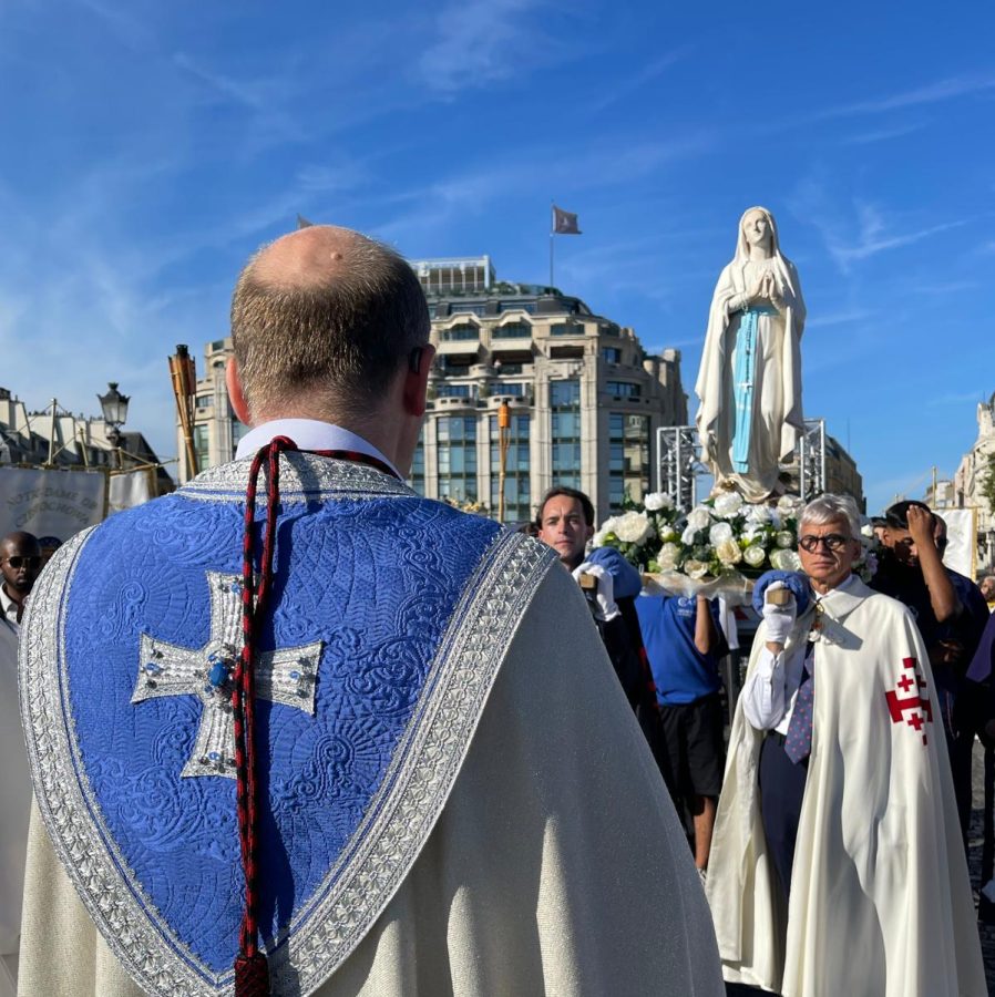 Procession catholique à Paris pour l'Assomption avec des prêtres et une statue de la vierge Marie